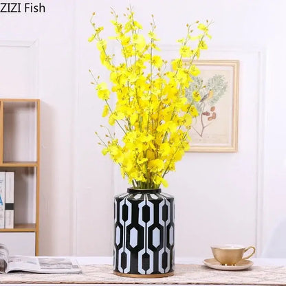 Black and white geometric stripes ceramic storage jar with gold rim holding yellow artificial flowers for living room decorbites decor