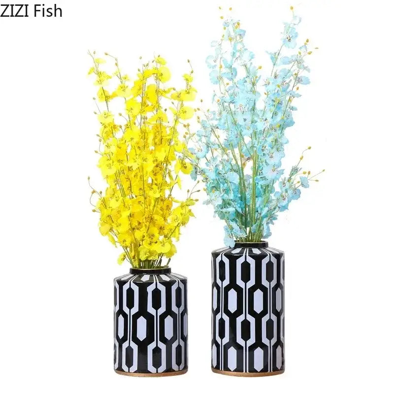 Two black and white geometric stripes ceramic storage jars with vibrant yellow and soft blue artificial flowers for living room decor