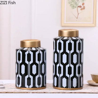 A tall geometric stripes ceramic storage jar in black and white with gold base holding light blue flowers for decorbites decor