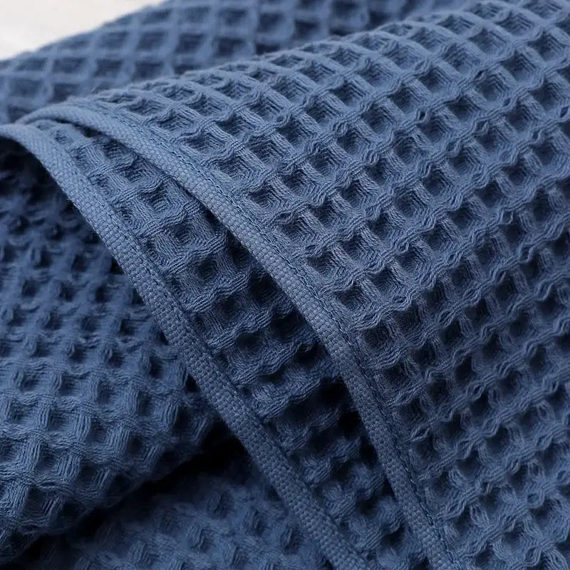 Navy blue waffle weave bath towel with textured grid pattern and decorbites geometric tassel design for bathroom decor