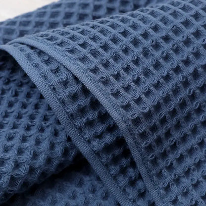 Navy blue waffle weave bath towel with textured grid pattern and decorbites geometric tassel design for bathroom decor