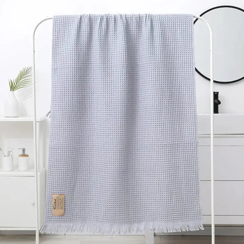 Light gray waffle-weave bath towel with soft textured surface and fringed edges for decorbites geometric tassel bath decor