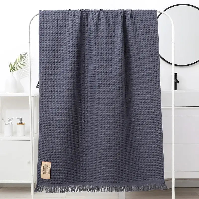 Dark gray bath towel with waffle weave soft texture and fringed edges decorbites geometric tassel bath towel design