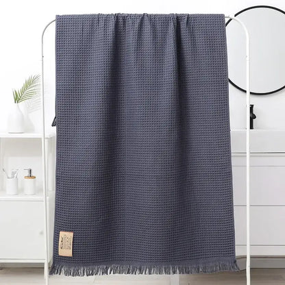 Dark gray bath towel with waffle weave soft texture and fringed edges decorbites geometric tassel bath towel design
