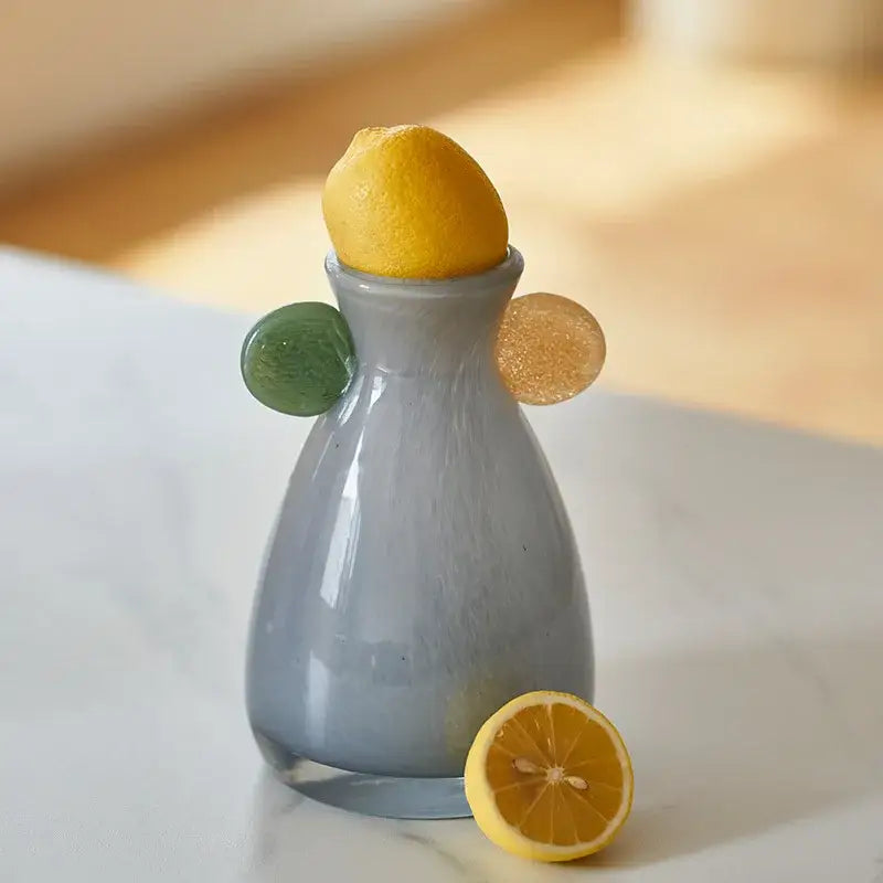 Gray geometric terracotta and blue ceramic vase with green and amber glass orbs and lemon decorbites geometric glass decor
