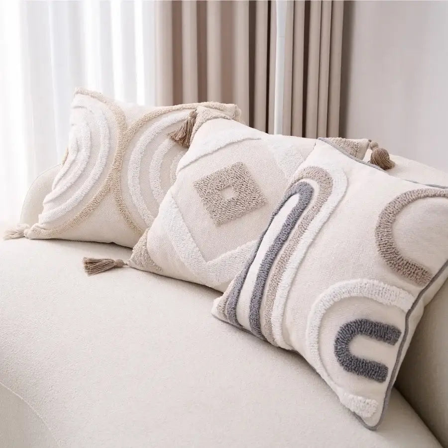 Cream-colored cushion cover with decorbites geometric tufted beige embroidery and tassel trim for living room decor