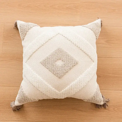 Cream-colored geometric tufted beige cushion cover with textured pattern and tassel trim for living room decorbites
