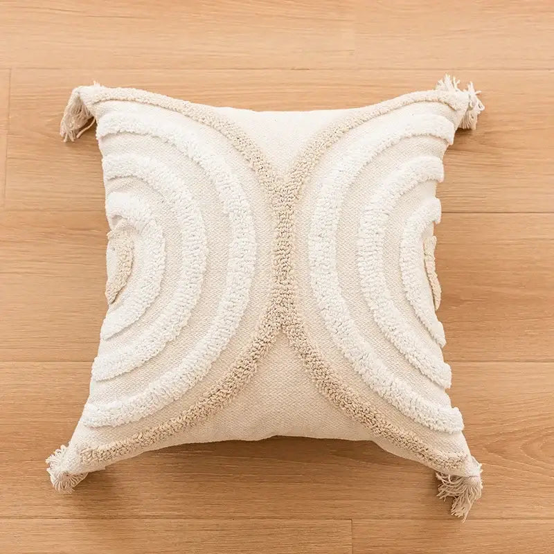 Cream-colored geometric tufted beige cushion cover with textured concentric circles and fringed tassel trim decorbites design