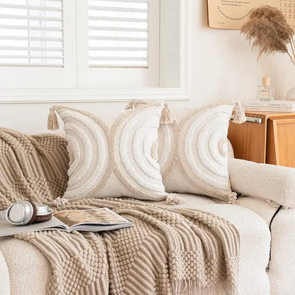 Cream-colored cushion cover with textured concentric circles and tassel accents decorbites geometric tufted beige design