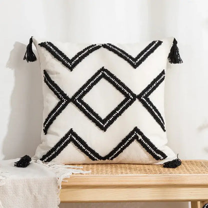 Cream-colored pillow cover with black geometric tufted embroidery and tassels for decorbites geometric tufted decor