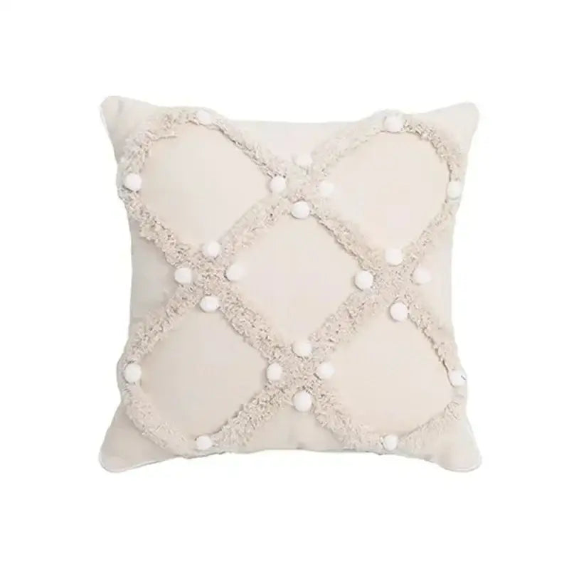 Cream-colored cushion cover with textured frayed crosshatch and white pom-poms for decorbites geometric tufted tassel decor
