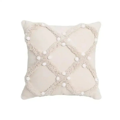 Cream-colored cushion cover with textured frayed crosshatch and white pom-poms for decorbites geometric tufted tassel decor