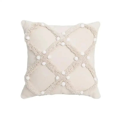 Cream-colored cushion cover with geometric tufted tassel pattern and white pom-poms for beige and gray decor