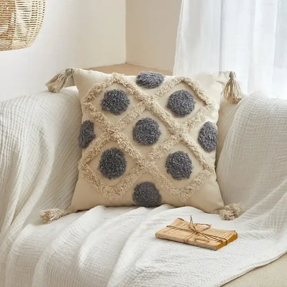 Beige cushion cover with gray pom-pom accents and geometric tufted tassel design for living room decor