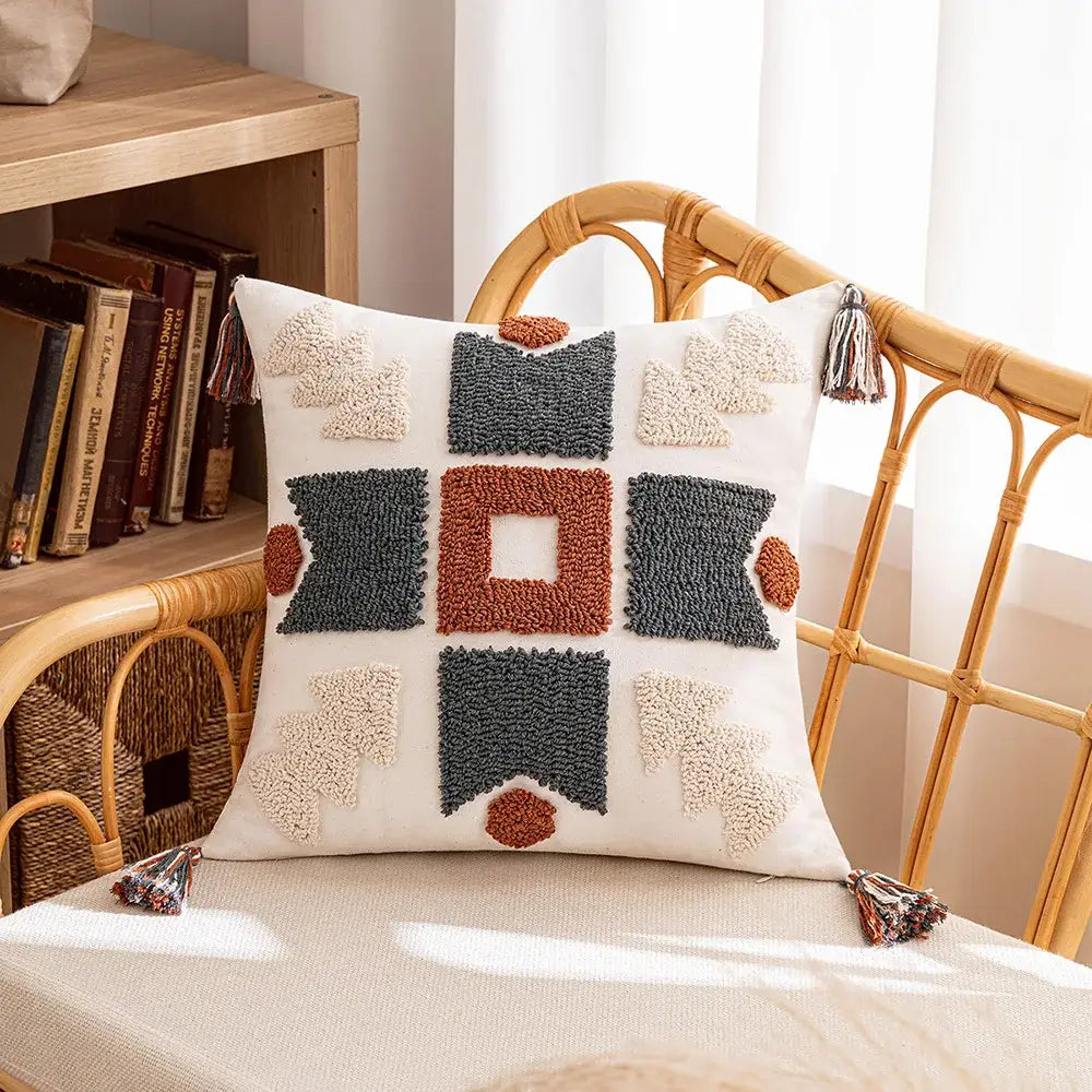 Cream-colored cushion cover with decorbites geometric tufted tassel patterns in gray terracotta and beige for living room decor