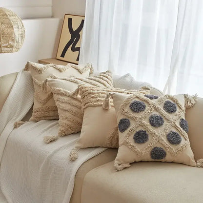 Beige cushion cover with gray pom-pom accents and geometric tufted tassel trim for living room decor
