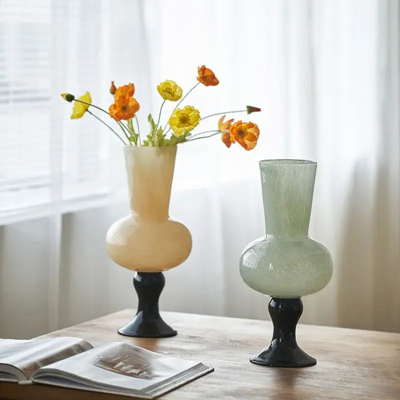 Two geometric vintage glass vases in mustard and cream with black bases holding vibrant orange and yellow poppies decorbites vintage glass vase