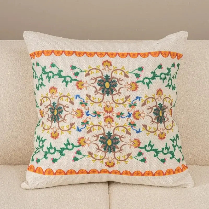A square off-white pillow cover with embroidered floral patterns and scalloped orange borders from decorbites geometric waves tufted collection