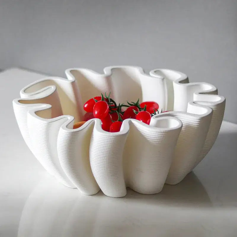 White ceramic fruit plate tray with geometric wavy ribbed design holding red cherry tomatoes for kitchen storage