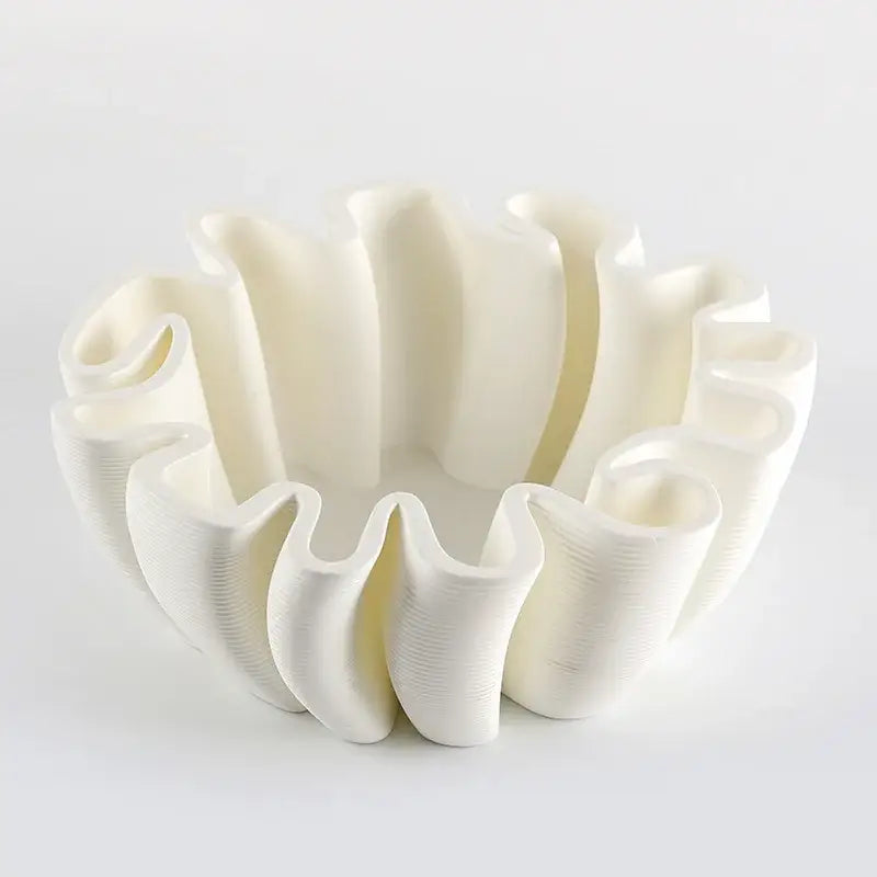 A white 3d-printed fruit plate tray with ruffled wavy rim and vertical ridges for kitchen storage