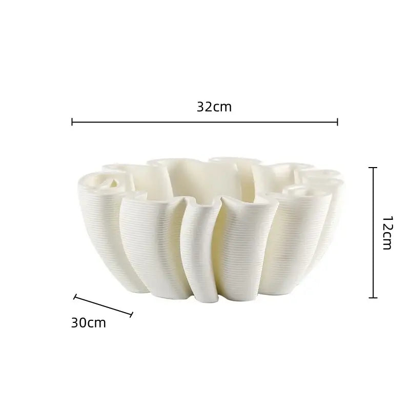 A white ceramic fruit plate tray with a fluted petal design and vertical ridges for kitchen storage