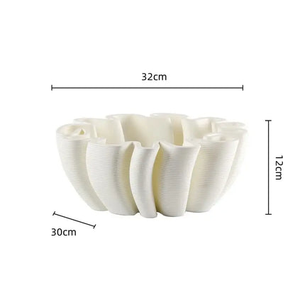 A white ceramic fruit plate tray with a fluted petal design and vertical ridges for kitchen storage