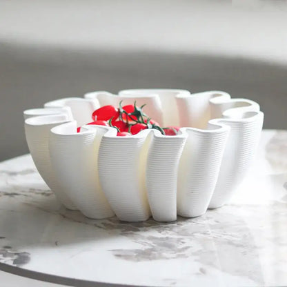White ceramic fruit plate tray with geometric wavy ribbed edges holding cherry tomatoes for kitchen storage