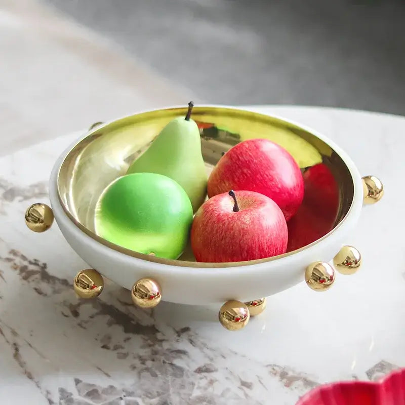 Geometric white and gold ceramic fruit bowl round with gold metallic interior and decorative golden ball feet