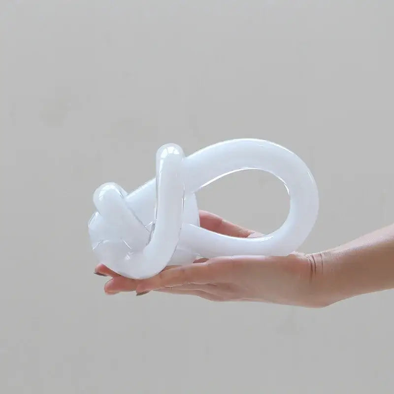 A translucent white glass twine knot sculpture with a smooth glossy finish for home decor by decorbites geometric glass