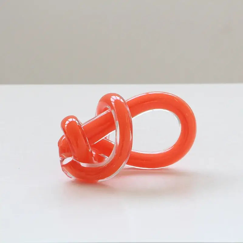 Vibrant orange glass twine knot sculpture with smooth glossy finish and transparent sections for home decor by decorbites geometric glass