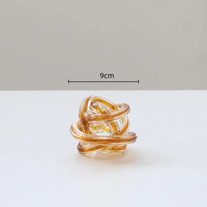 A translucent amber glass geometric wound ring with a twisted twine sphere design for decorbites living room decor