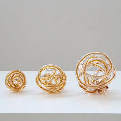 Three amber-tinted geometric wound glass twine spheres with intricate twisted and coiled designs for living room decorbites decor