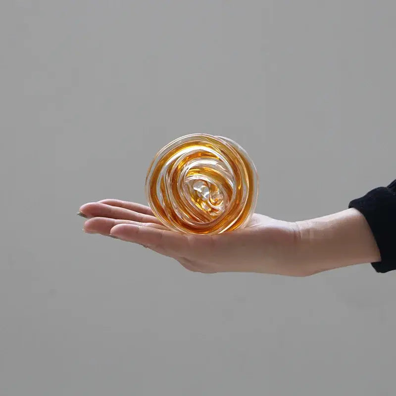 A translucent amber geometric wound glass twine sphere with a swirling spiral design for living room decor