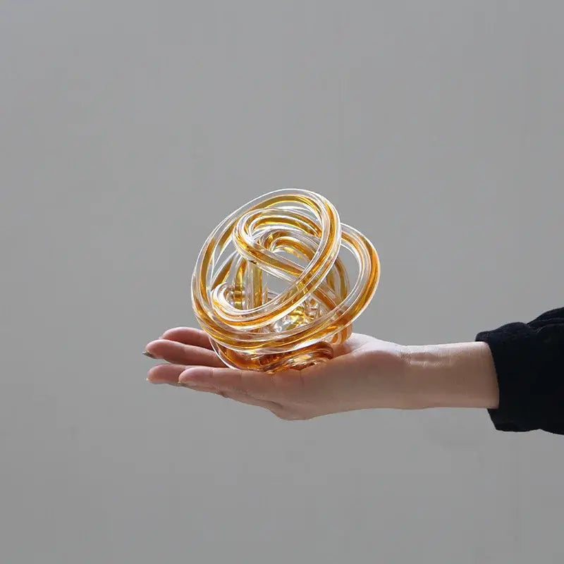 Translucent amber geometric wound glass twine sphere with intricate loops for living room decor by decorbites