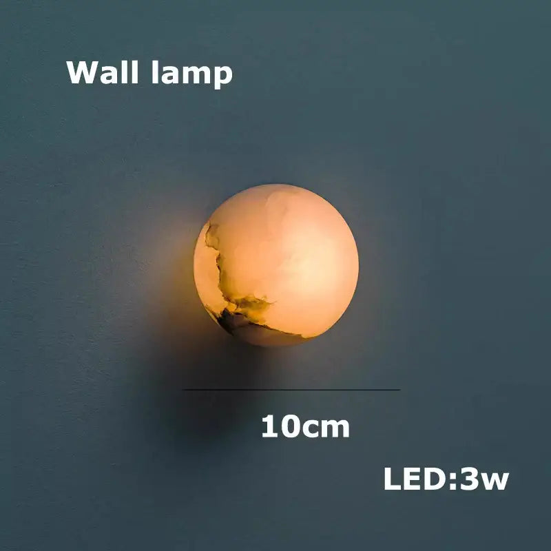 A warm glowing spherical wall lamp with textured crackle surface in creamy white for decorbites geometry marble chandelier