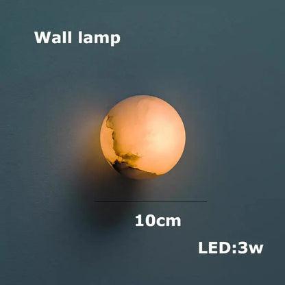 A warm glowing spherical wall lamp with textured crackle surface in creamy white for decorbites geometry marble chandelier