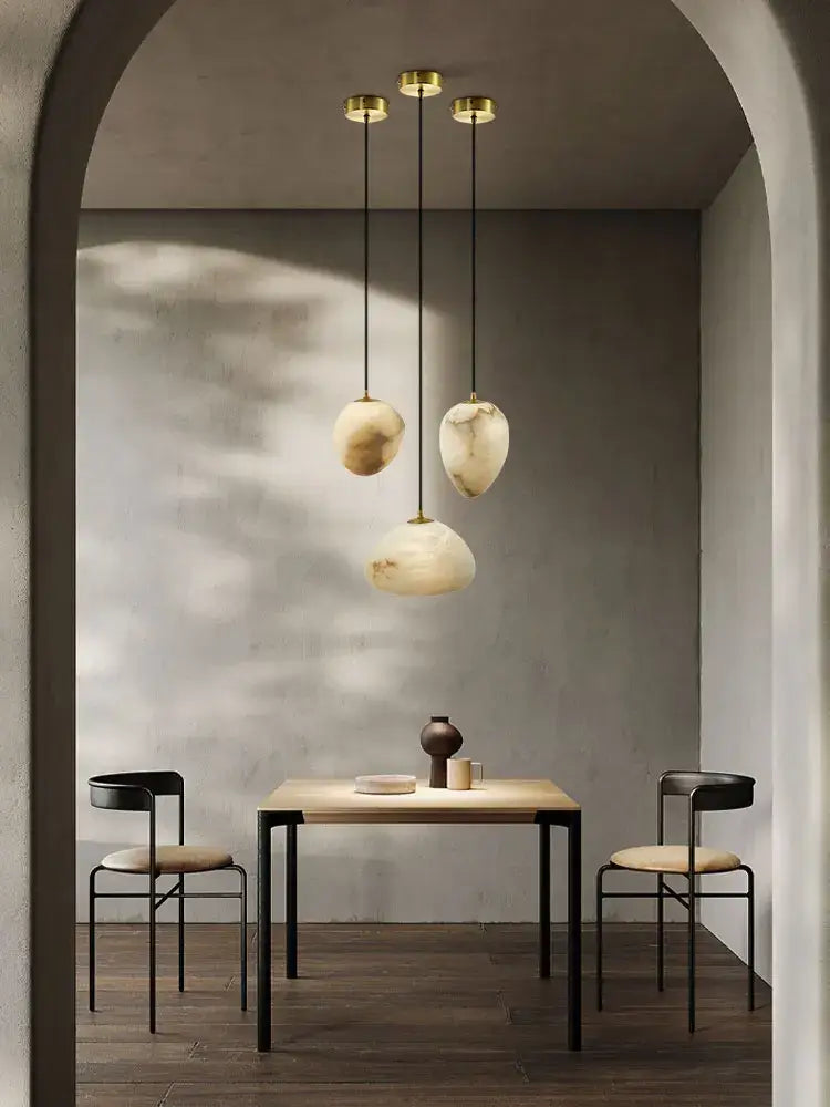 Three pendant lights with golden fixtures and organic creamy white marble shades for decorbites geometry marble chandelier