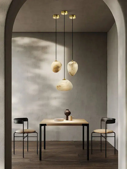 Three pendant lights with golden fixtures and organic creamy white marble shades for decorbites geometry marble chandelier