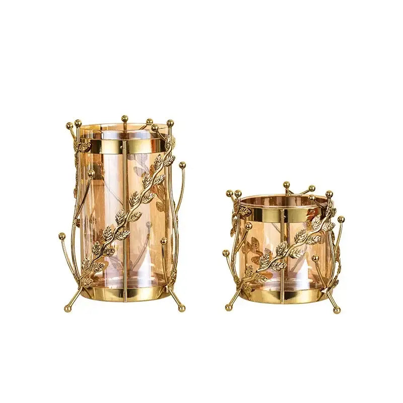 Gilded tree branch gold-toned metal candle holders with intricate leaf vine design and clear glass interiors for decor