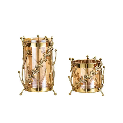 Gilded tree branch gold-toned metal candle holders with intricate leaf vine design and clear glass interiors for decor