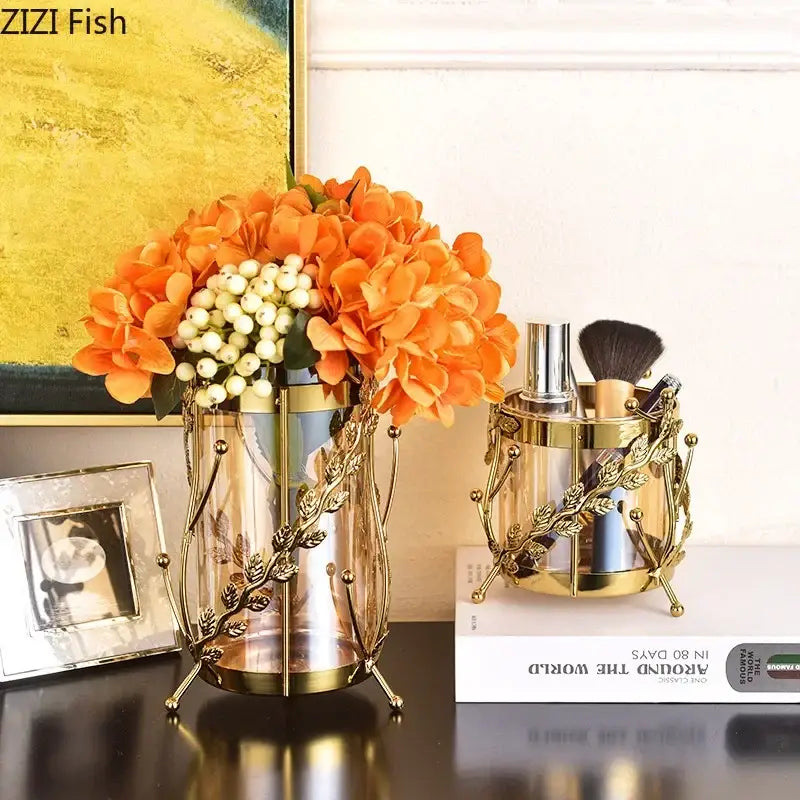 Gold-toned gilded tree branch glass vase with intricate leaf metalwork holding orange hydrangeas and white berries
