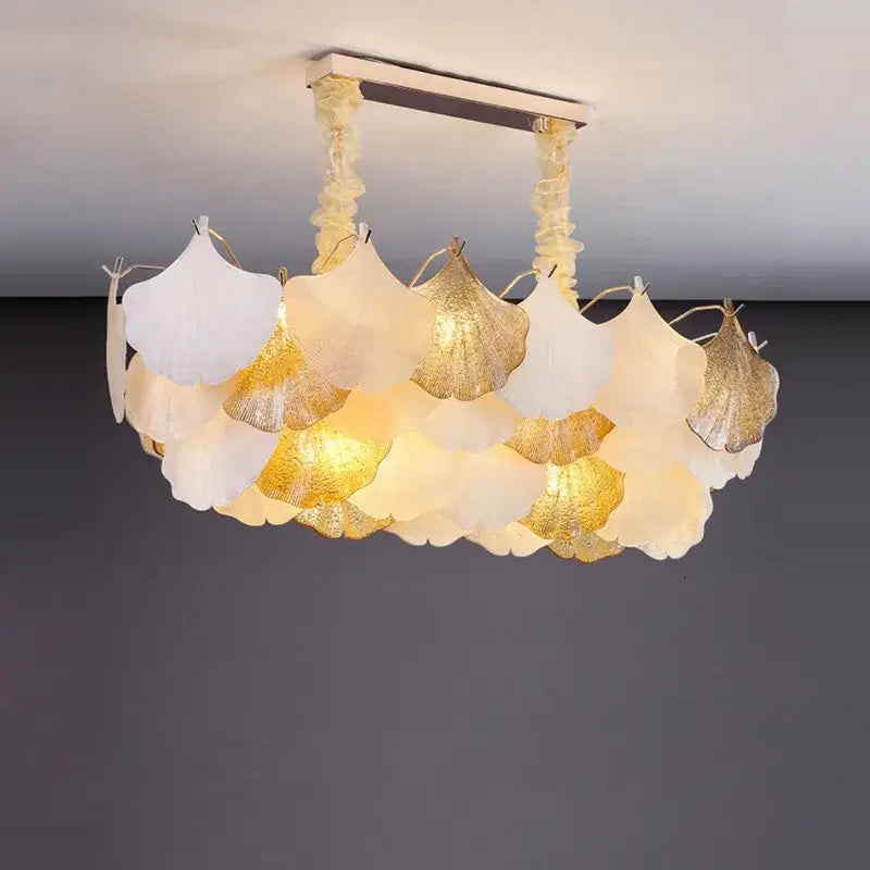 A decorbites ginkgo art dimmable chandelier with layered white and gold ginkgo leaf shades for dining room decor