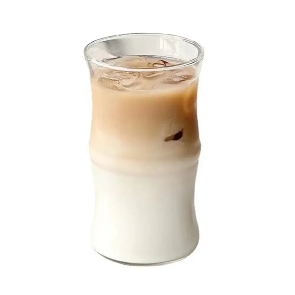 A clear glass bamboo knot mug with bamboo-inspired design filled with layered iced coffee drink