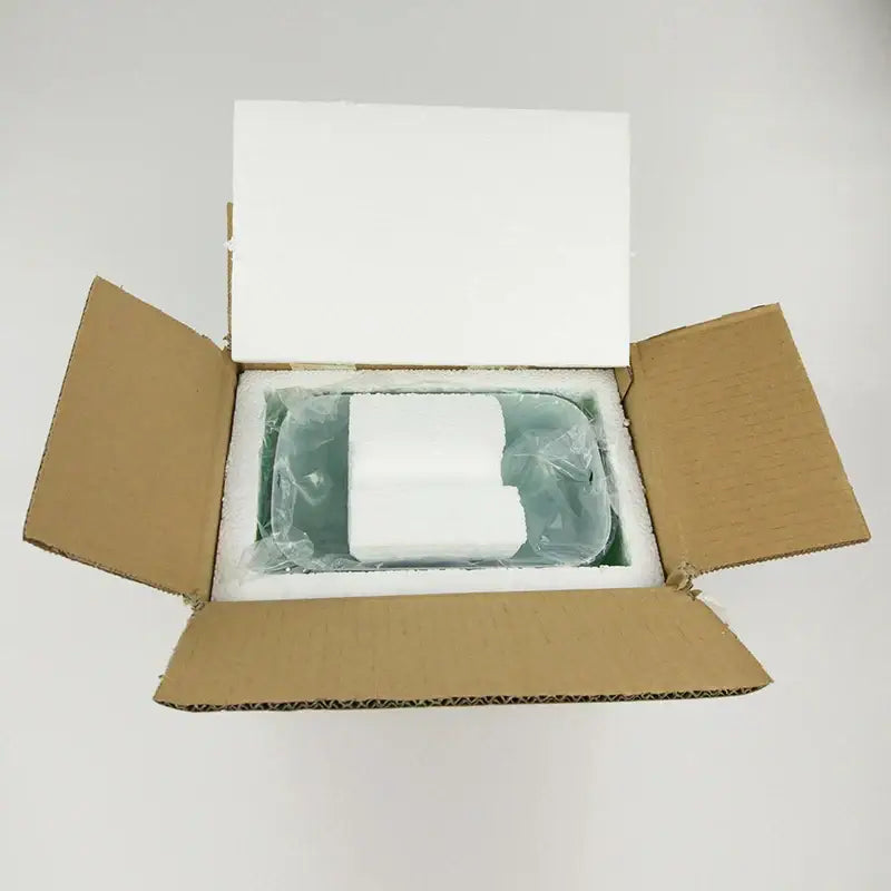 White rectangular electronic device nestled in foam inside a box for decorbites glass banker lamp shade product