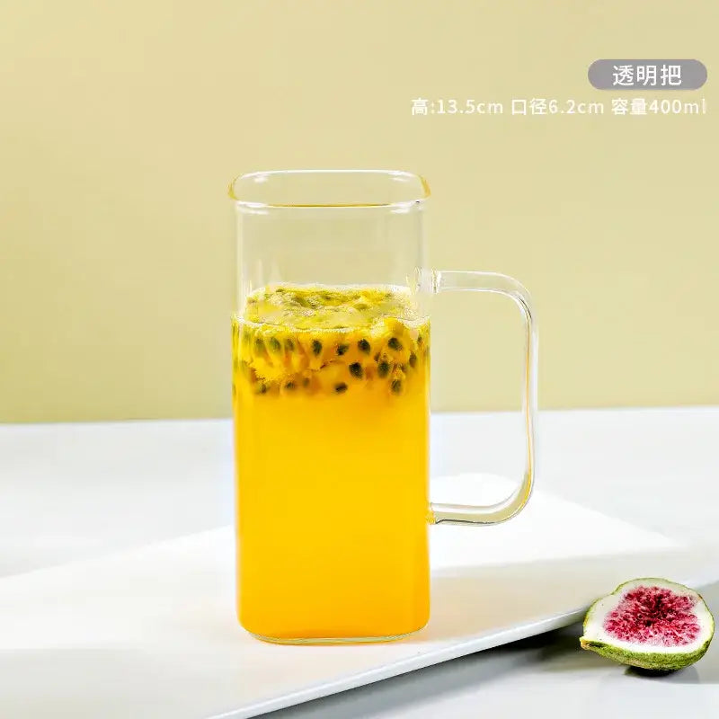 Clear glass drinking cup with transparent handle filled with yellow passion fruit drink by decorbites glass drinking cups