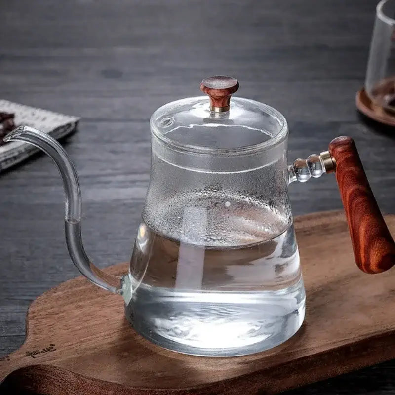 Clear glass decorbites glass goose beak kettle with rich brown wooden handle and sleek curved spout for pour over coffee