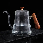 Clear glass goose beak kettle with wood handle and lid knob filled with water by decorbites glass goose for kitchen use