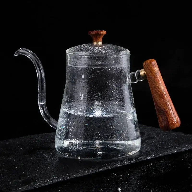 Clear glass goose beak kettle with wood handle and lid knob filled with water by decorbites glass goose for kitchen use