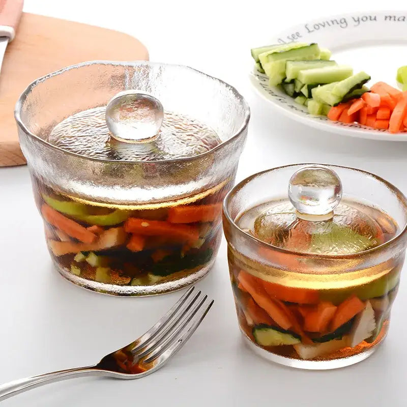 Clear glass kimchi storage jar with textured rounded body and matching lid featuring small spherical handle decorbites storage jar