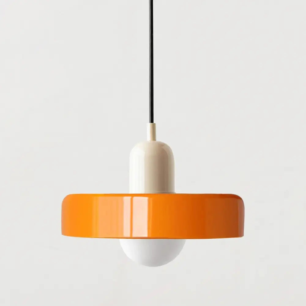 Vibrant orange glass pendant lighting with a glossy finish and cream-colored cylindrical base in Bauhaus style